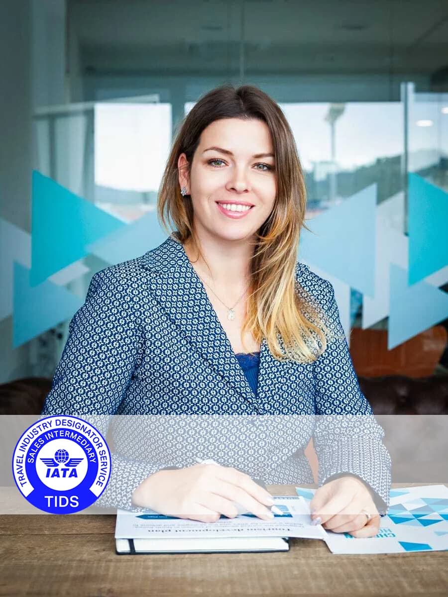 A LUXEme travel specialist in an office with the IATA TIDS emblem